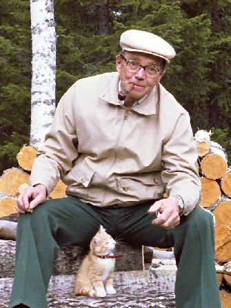 Bengt Sandström sitter på en Vedstapel
